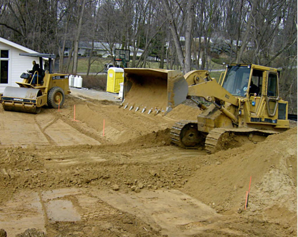 Yellow bulldozer and compactor grading land for construction by JKT Outdoor Services Ltd. in Parkland County, Alberta, Canada.