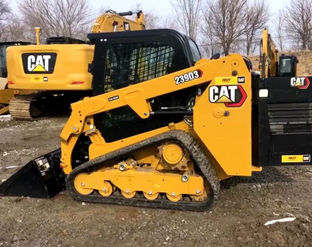 Yellow CAT skid steer used by JKT Outdoor Services Ltd. for gravel pad installation in Parkland County, Alberta, Canada.